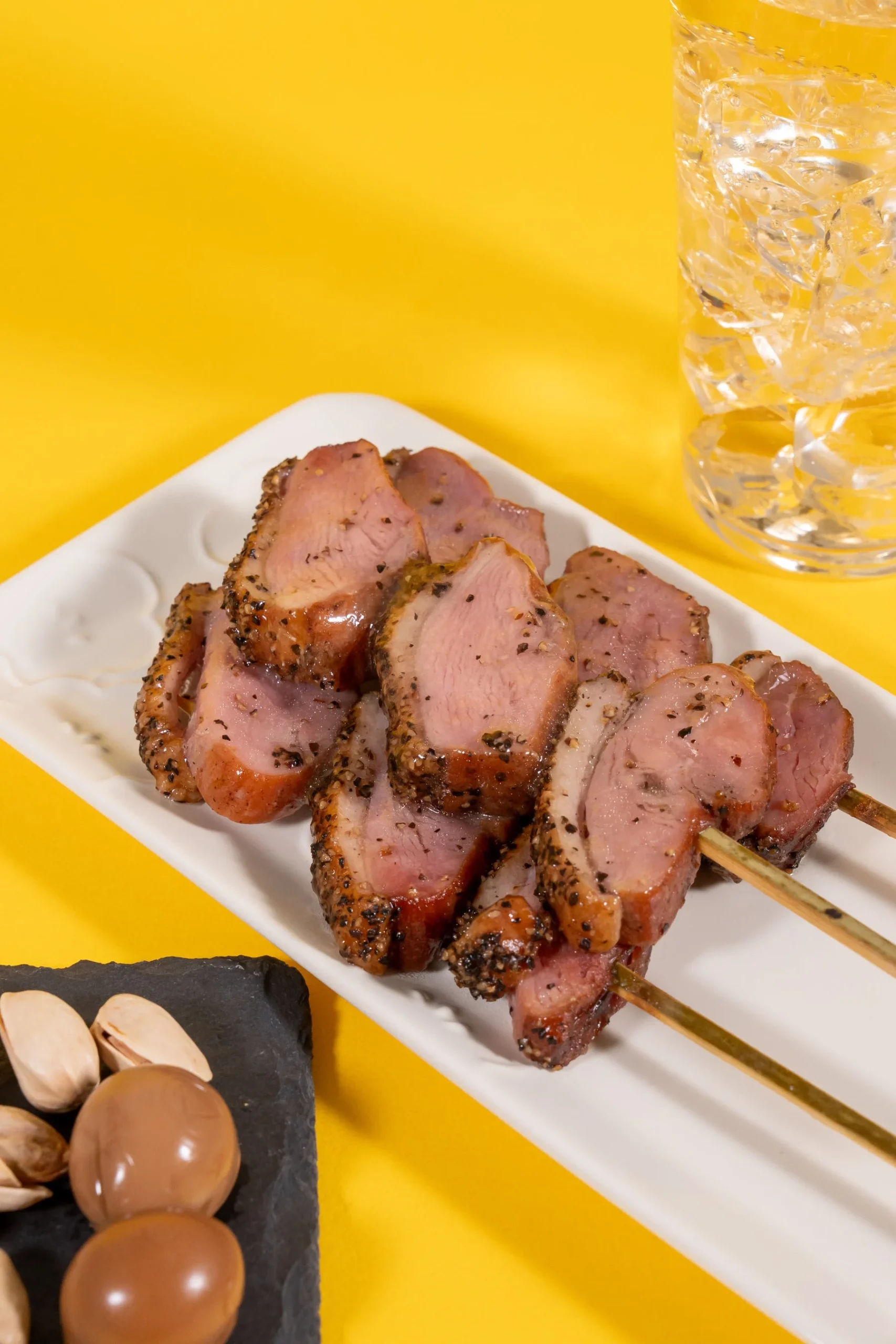 燻製あい鴨ロース串の薄切り肉が串に刺さった状態