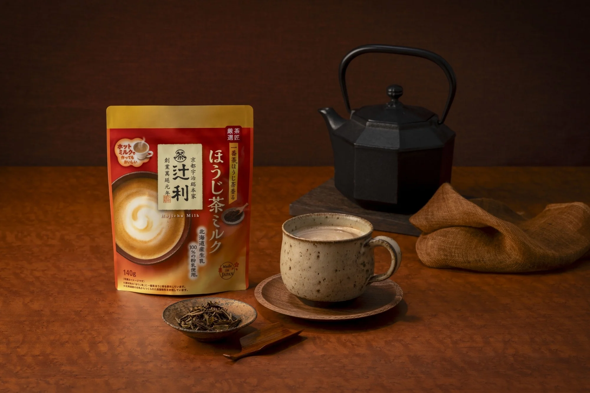辻利ほうじ茶ミルクのパッケージと、湯呑みに注がれた完成品、茶葉、鉄瓶のイメージ