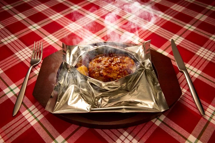 湯気が立ち上るデミグラスソースの包み焼きハンバーグ