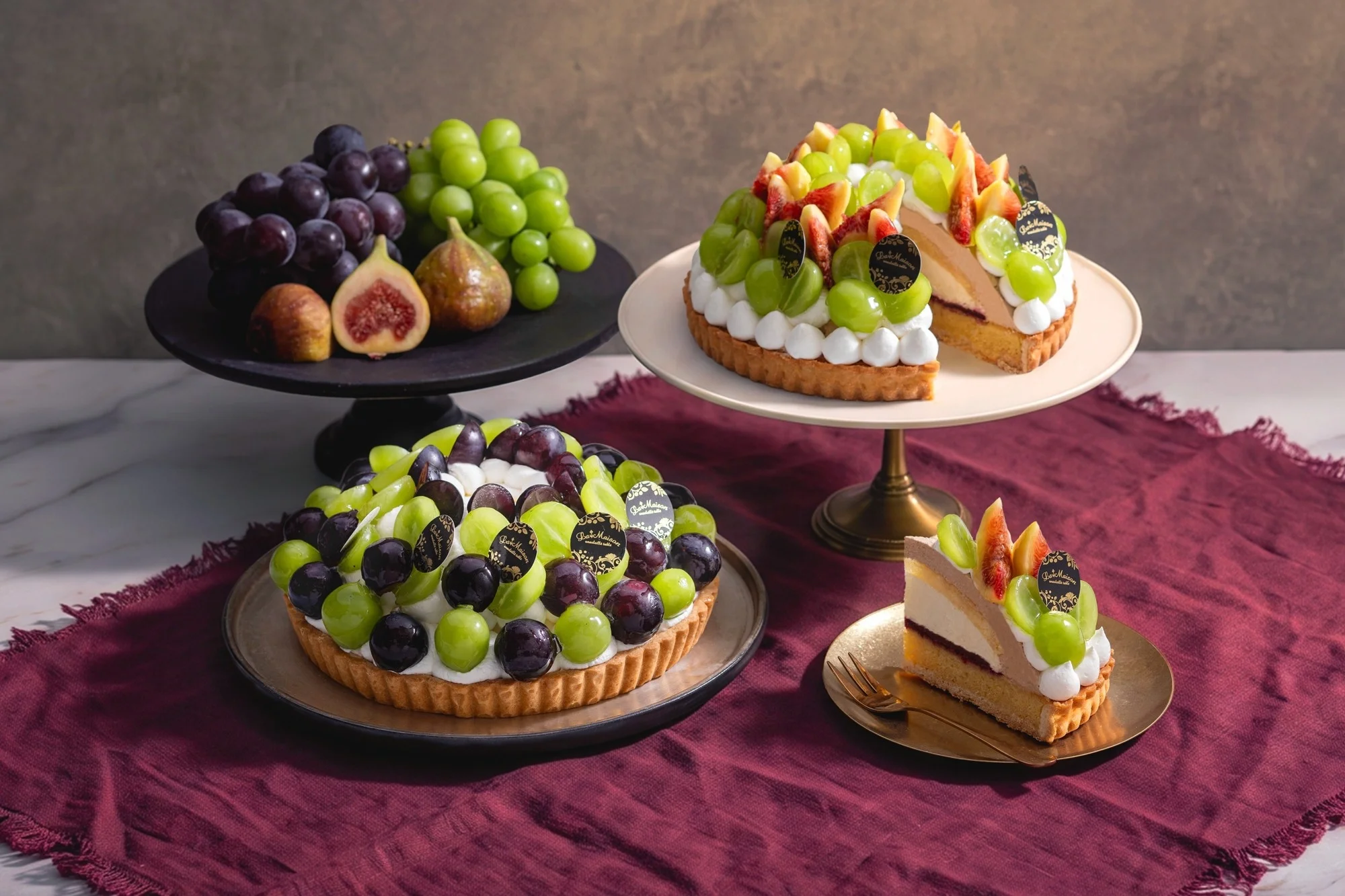 ブドウとイチジクをふんだんに使用したタルトのホールとカットされたケーキ