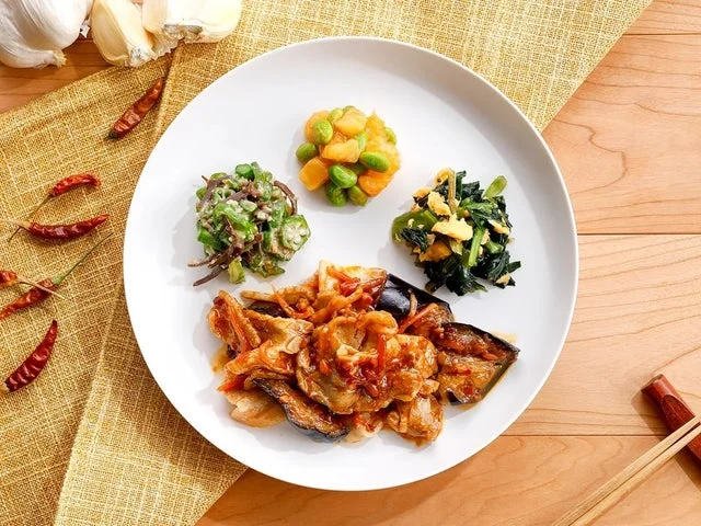 「なすと豚バラの甘辛中華だれ」のメイン料理と副菜が盛られたプレート