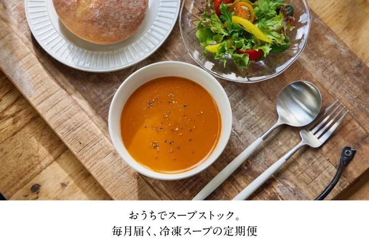 調理されたスープ、パン、サラダが並ぶ食卓の様子