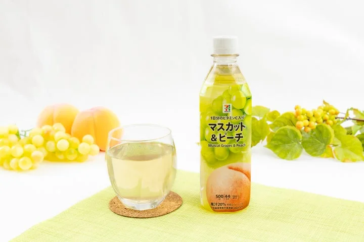 セブンプレミアム マスカット＆ピーチのペットボトル飲料と、グラスに注がれた中身、添えられた果実