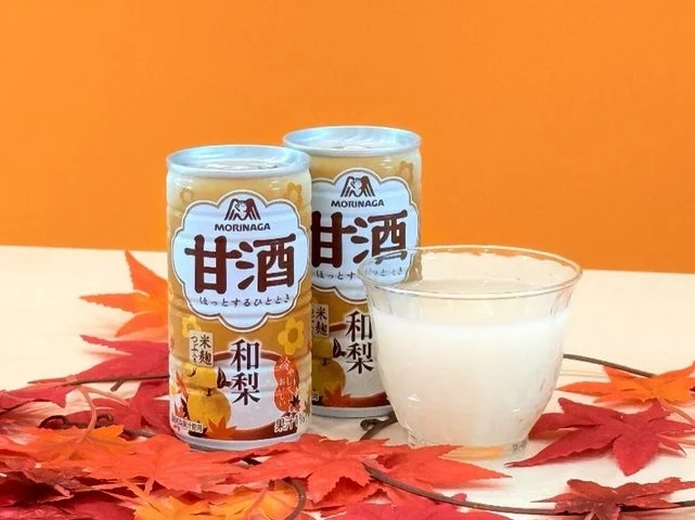 紅葉を添えたテーブルに置かれた「甘酒＜和梨＞」の缶とグラスに入った甘酒