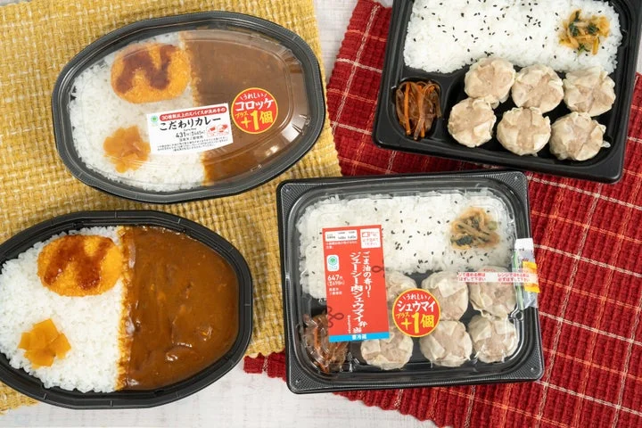 「こだわりカレー」と「肉シュウマイ弁当」の2種類のお弁当が並んでいる様子