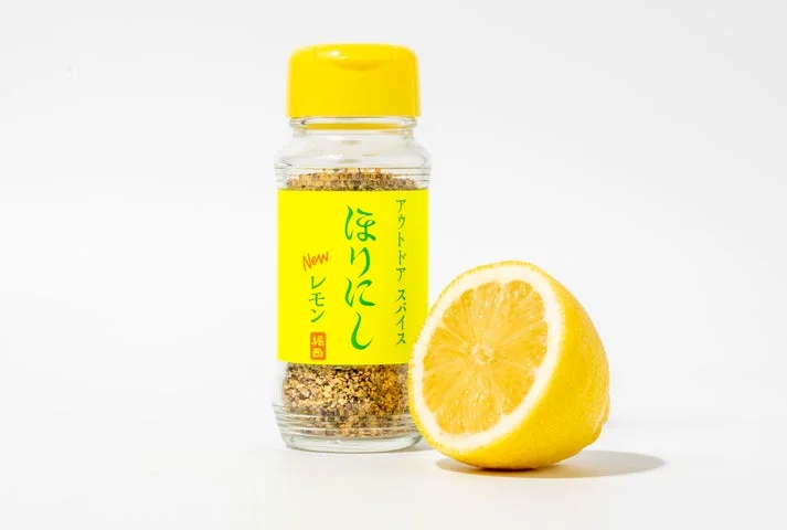 「アウトドアスパイス ほりにしニューレモン」のボトルとカットされたレモン