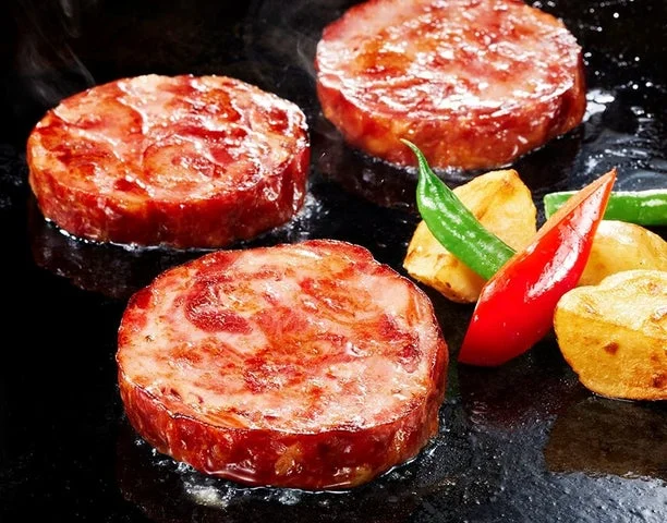 鉄板で焼いている厚切りタンステーキと付け合わせの野菜