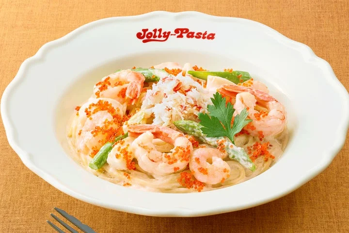 カニのほぐし身、エビ、イカ、アスパラがトッピングされたカニのクリームソースパスタ