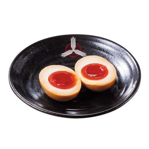 黒い皿に盛り付けられた二つ割りの味付玉子