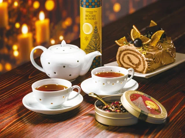 紅茶、ティーポット、ブッシュ・ド・ノエルが並ぶティータイムの様子