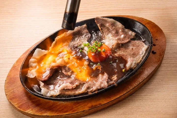 バーナーで炙られる黒毛和牛の焼しゃぶと卵黄