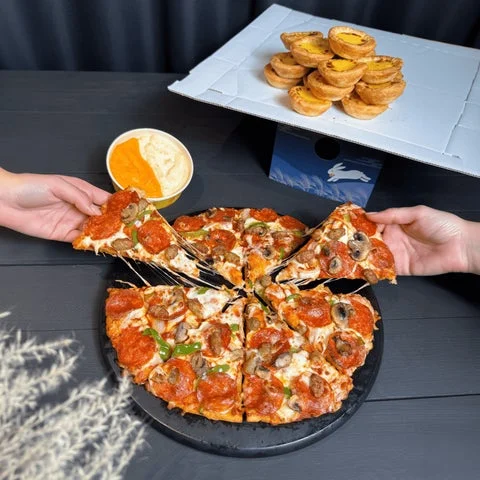 ピザをチーズソースにディップし、エッグタルトを積み上げた食卓風景