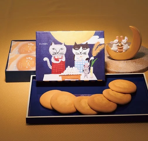 猫と月見だんごを描いたパッケージと、並べられた生サブレ