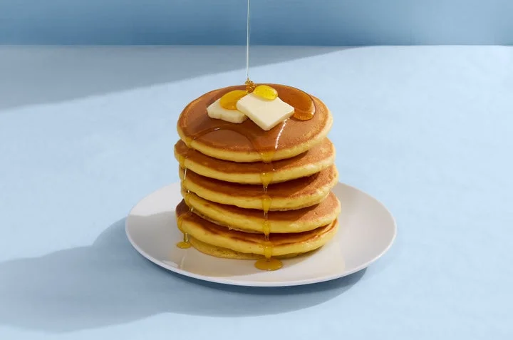 シロップとバターをかけたパンケーキの山