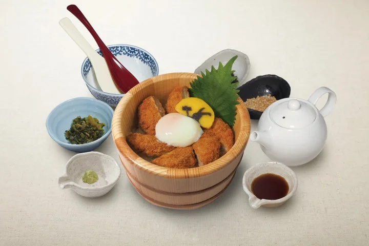 木製のおひつにひれかつ、温泉たまご、うさぎかまぼこを盛り、だしと薬味を添えた月見メニュー