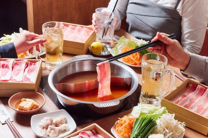 二色鍋でしゃぶしゃぶを楽しむ食事シーンと、肉や野菜の盛り合わせ