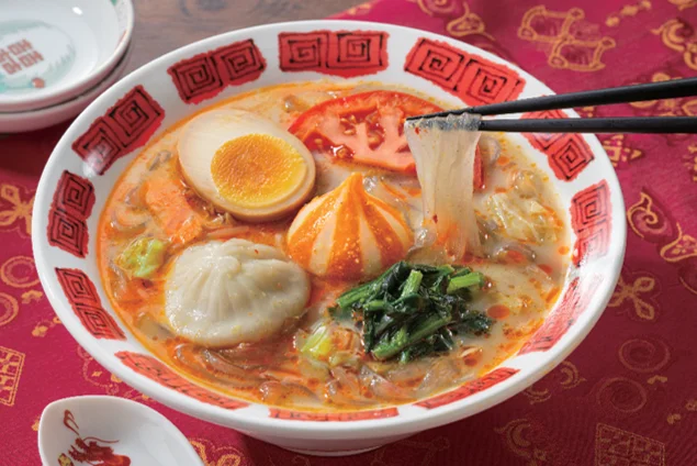 「小籠包入り!」紅白点心の麻辣湯。赤いスープに小籠包や半熟卵、野菜が添えられた様子