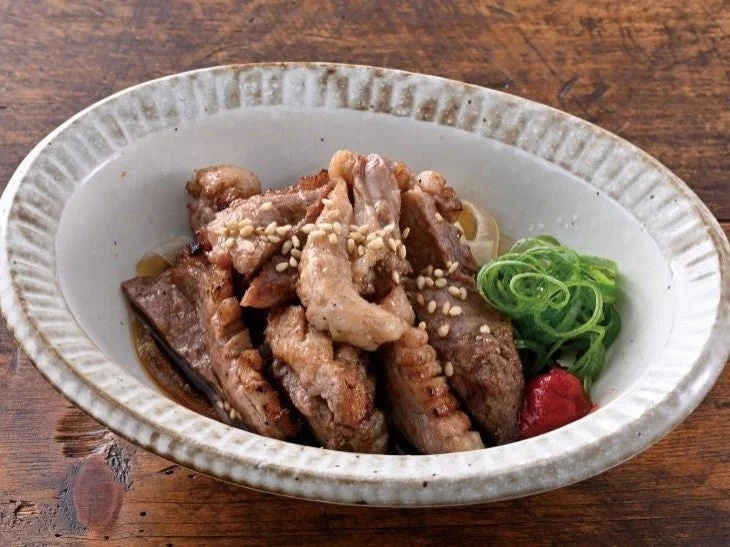 合鴨の炭火炙りぽん酢。皿に盛られた合鴨肉とネギの画像