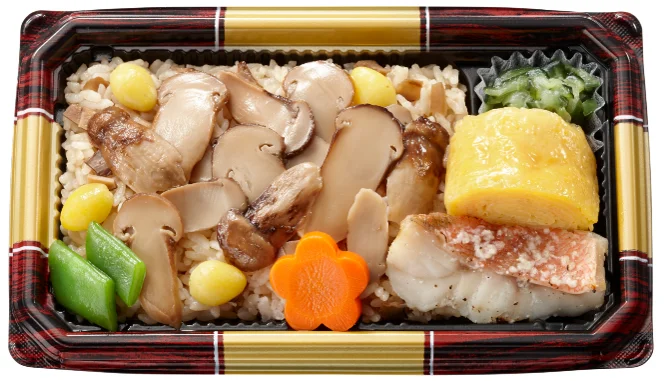 松茸ごはんのイメージ画像。松茸スライス、銀杏、赤魚の塩麹焼き、厚焼き玉子が入った弁当