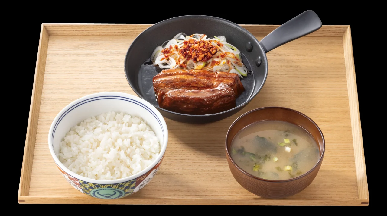 厚切り豚角煮定食。黒い器に豚角煮と白髪ねぎ、ご飯、みそ汁が木製トレイに並ぶ