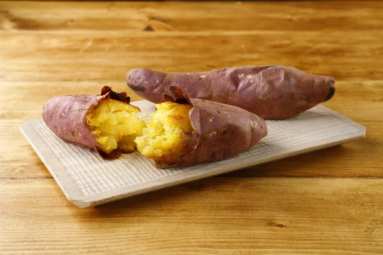 紅天使の焼き芋。皮付きの焼き芋と、黄色い果肉が露出した状態を木製トレイに並べた写真。