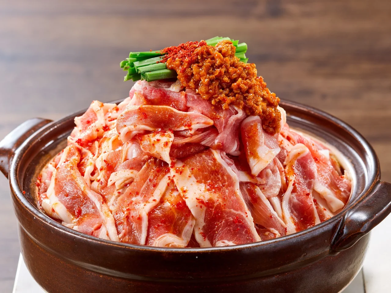 赤から肉マシマシ鍋。土鍋に豚肉を大量に盛り、味噌とネギを添えた状態