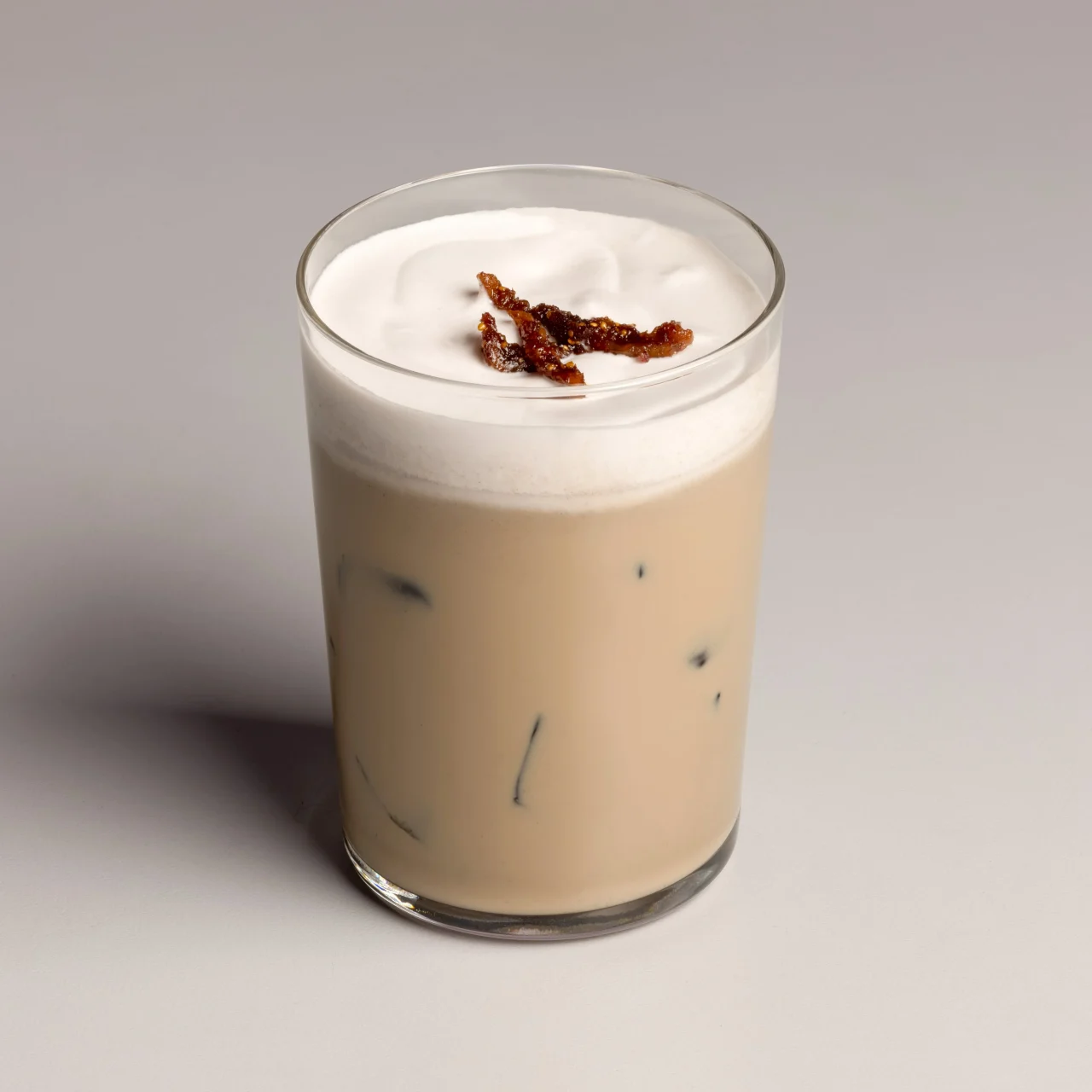 フィグクリーム ラテ。グラスに注がれたドリンクにクリームとドライフィグが添えられています。