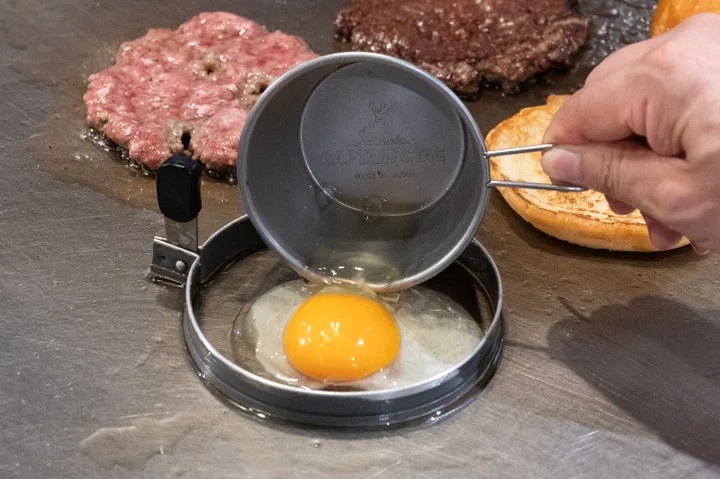 グリドル上のリング型で卵を焼き、調理している様子。