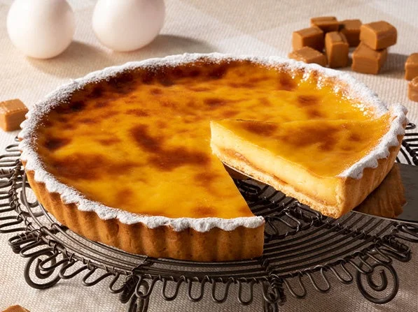 網の上に乗ったキャラメルプリンタルト。一部がカットされており、プリン生地とキャラメルソースが見える。
