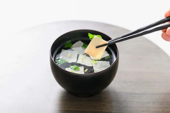 箸で持ち上げた生ゆばが入ったお吸い物