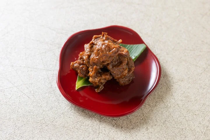 赤い小皿に盛られた飛騨牛すね味噌煮込み