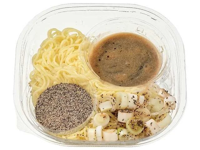 「冷やしコショウそば」の容器に入った麺、スープ、大量のあらびきコショウ、ネギ
