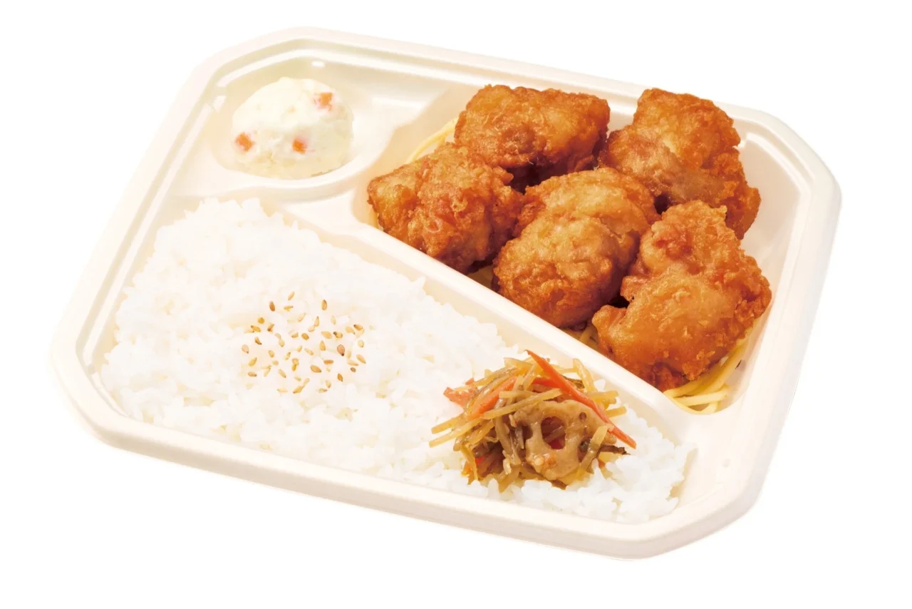 唐揚弁当。白い容器に唐揚げ、ご飯、漬物、ポテトサラダが盛られている