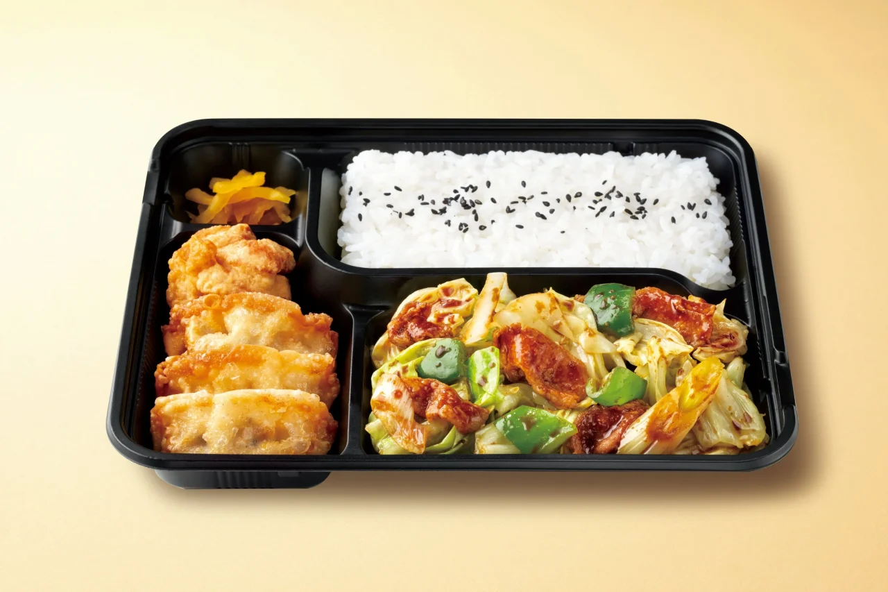黒い容器に唐揚げと揚げ餃子、野菜炒め、ご飯が入ったスタミナホイコール弁当