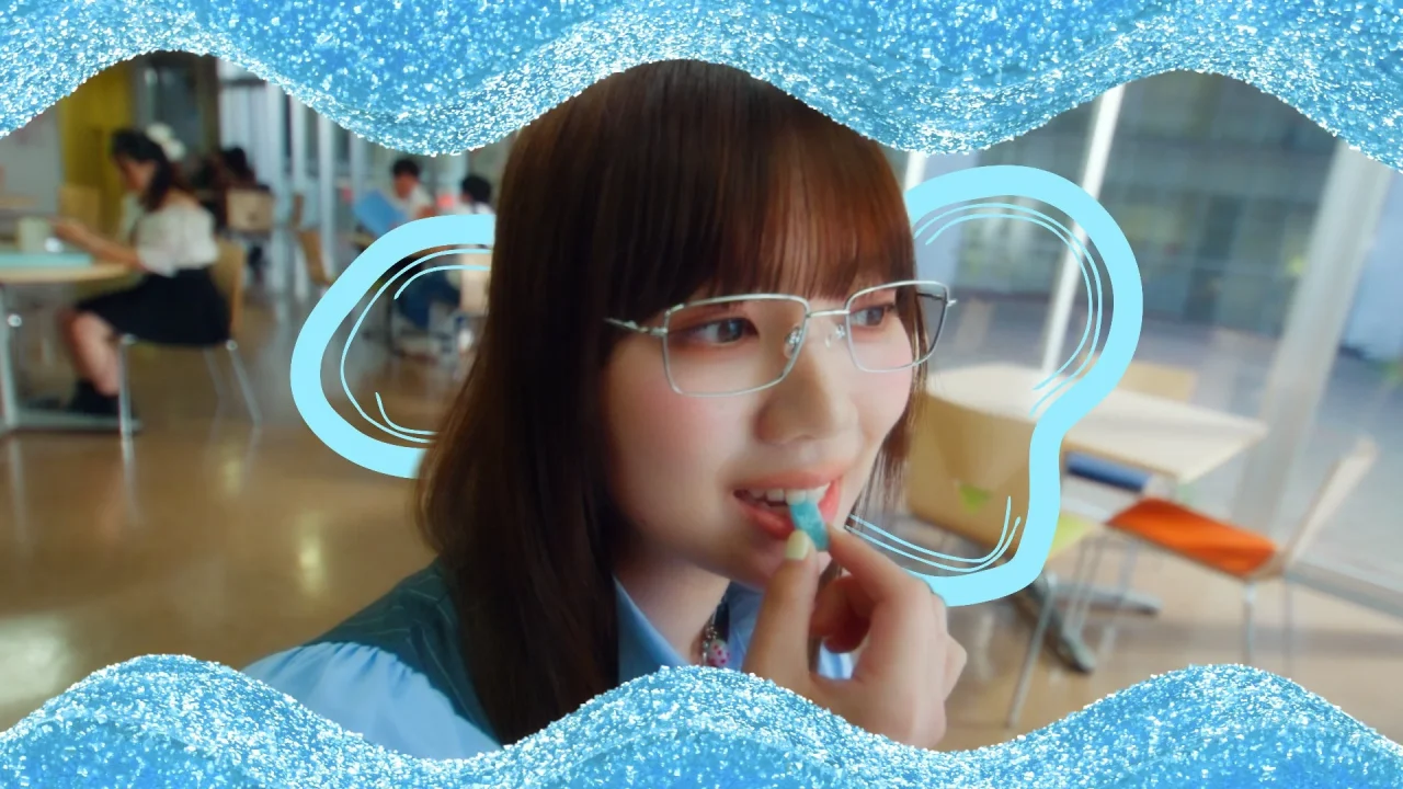 カンデミーナグミ新WEB CMの一場面で、女性がキャンディを口に運ぶ様子