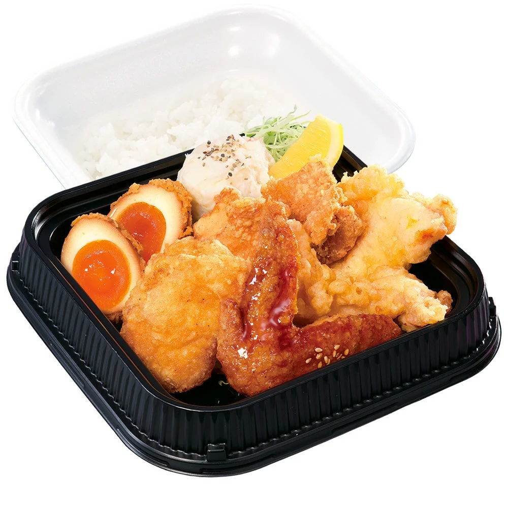 黒い容器に入った5種盛り弁当。ご飯、からあげ、卵、ポテトサラダ、レモンが写る。