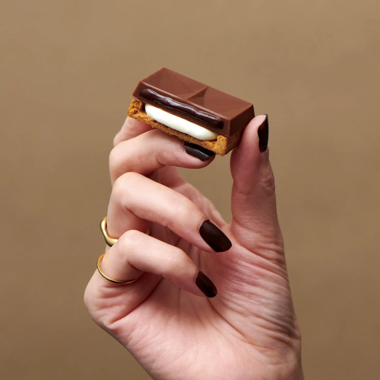 ショコラバターサンドを手に持ち、断面のクリームとクッキーが見える様子