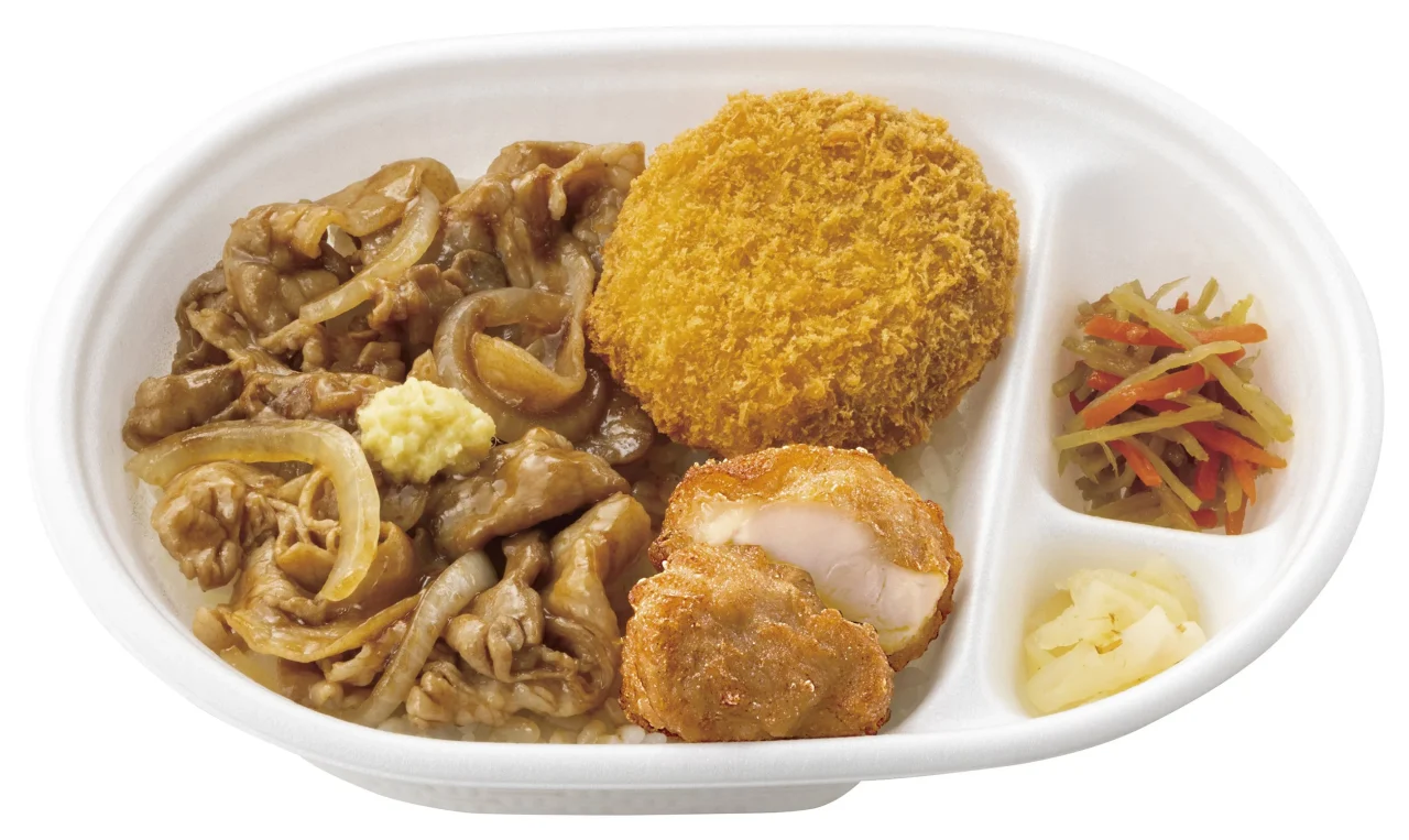 『とりかつ得弁ランチ』の白い弁当箱。唐揚げ、しょうが焼き、漬物が入っている。