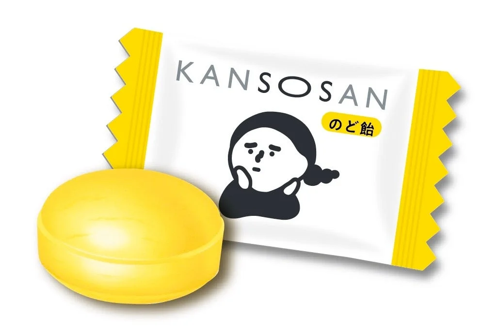 KANSOSANのど飴の個包装と黄色い飴玉