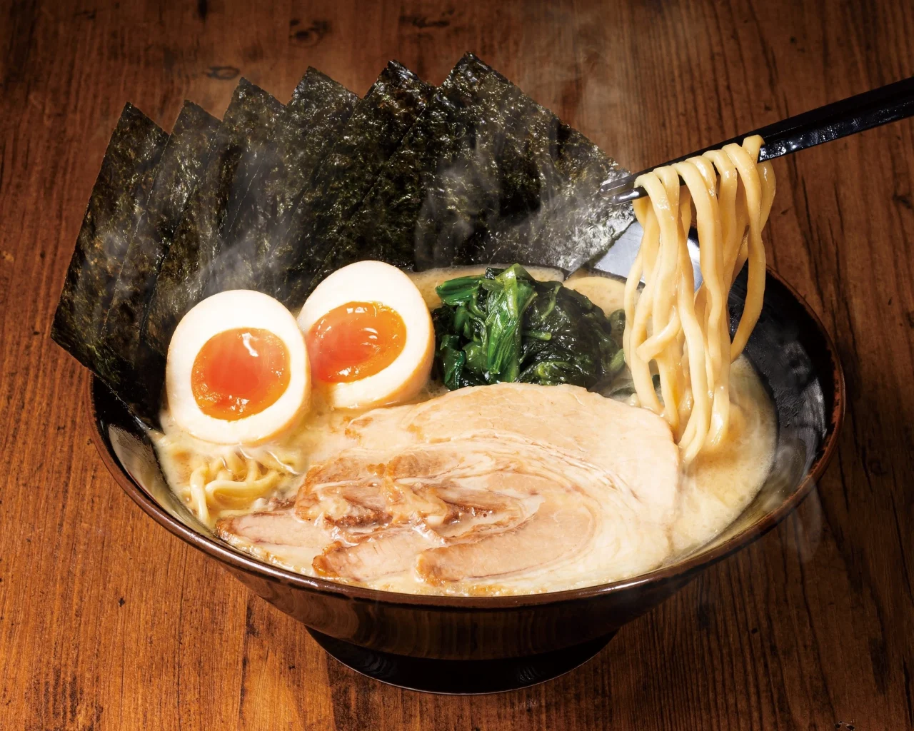 壱角家の家系ラーメン。豚骨スープにチャーシュー、半熟卵、海苔、青菜が乗った中太麺。