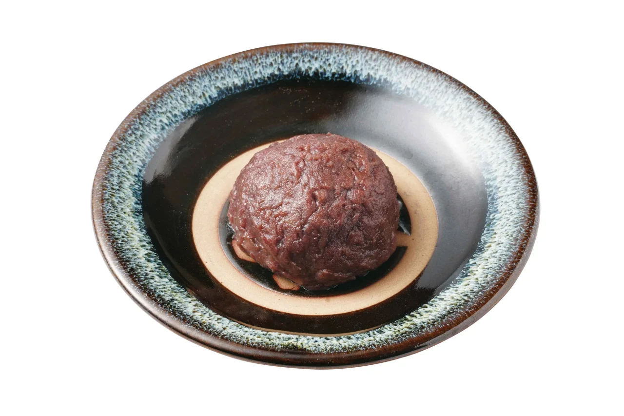茶色の皿に盛られた丸いぼた餅