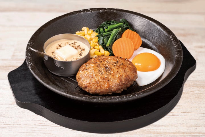 濃厚なカルボナーラソースに目玉焼き、野菜を添えた白い月見ハンバーグ