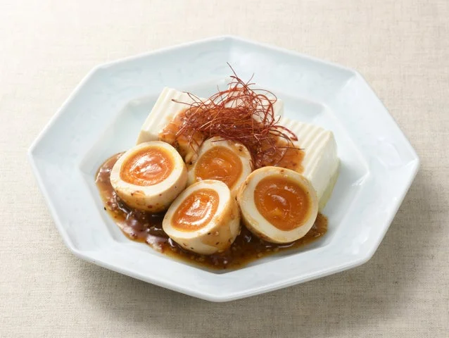 豆腐の上にのせられた「うま辛たまご」の盛り付け例