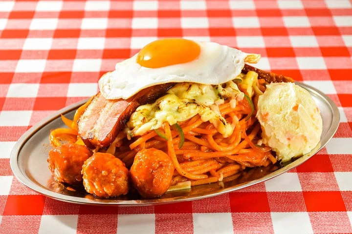 目玉焼きやポテトサラダなどのトッピングが乗ったナポリタン