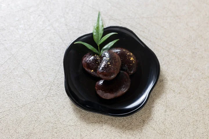黒い小皿に盛られた金箔が添えられた花まめ
