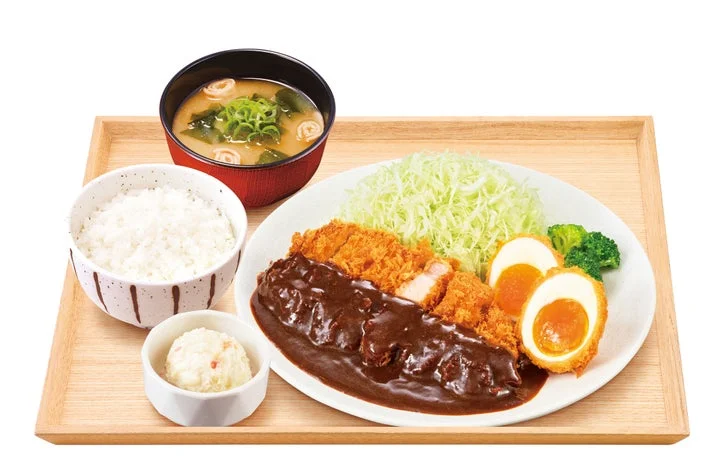 デミグラスソースをかけたとんかつと半熟たまごフライ、ご飯、味噌汁、ポテトサラダが並ぶ定食