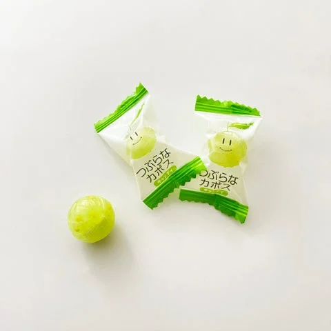つぶらなカボスキャンディの個包装2つと、包み紙を外した黄色いキャンディ1個