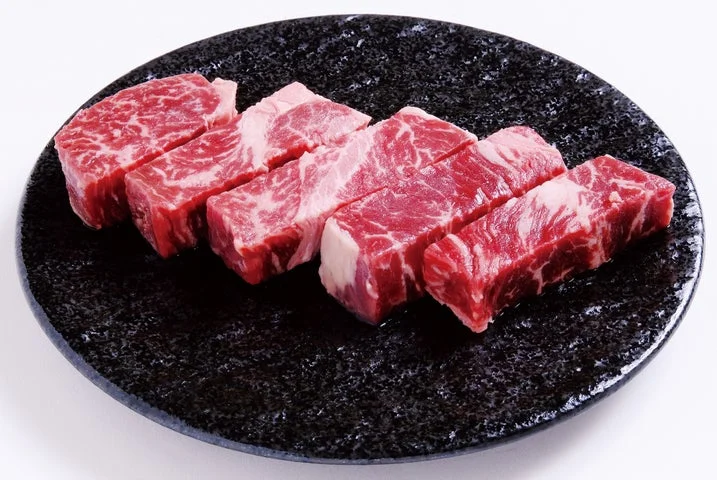 黒い皿に並べられた厚切りの生牛肉