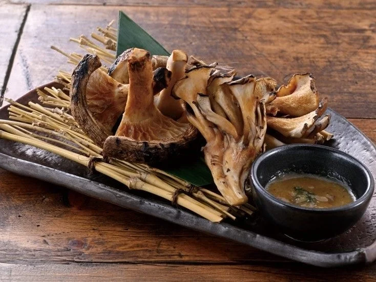 肉厚椎茸と舞茸の炭火焼。鉄皿に炭火で焼いたきのこが盛り付けられている