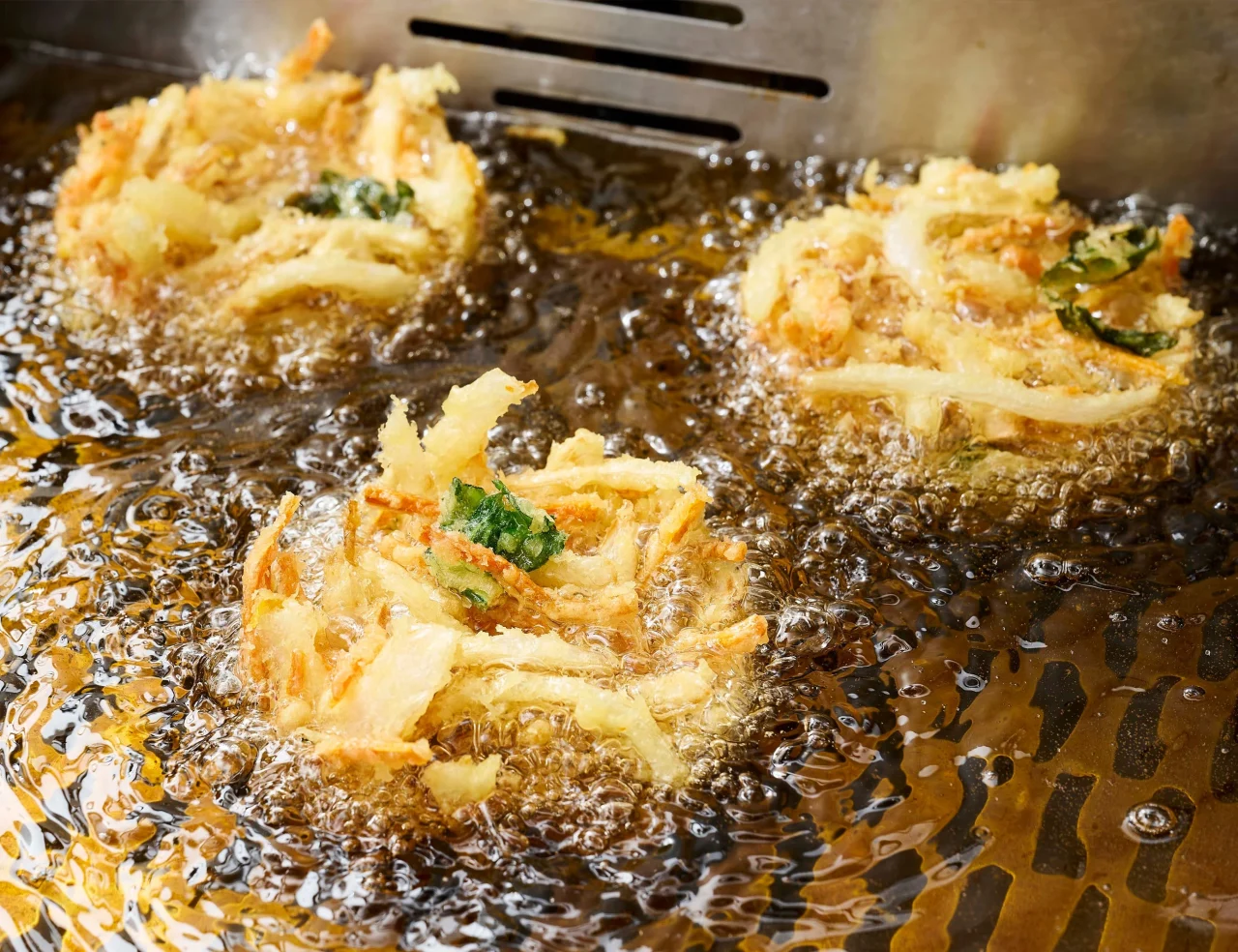 油で揚げられている自家製かき揚げ